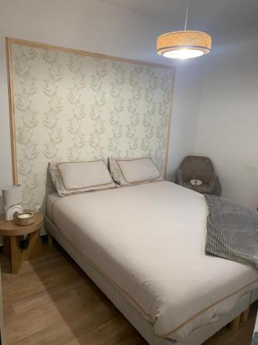 - une chambre avec un lit blanc et un mur dans l'établissement résidence Nassau3 F2 2eme étage, à Beauvais