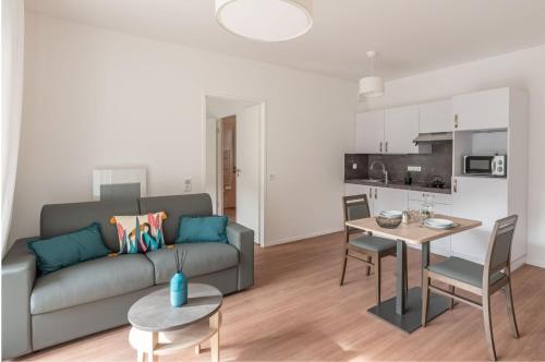 un salon avec un canapé et une table dans l'établissement Résidence Angers, à Angers