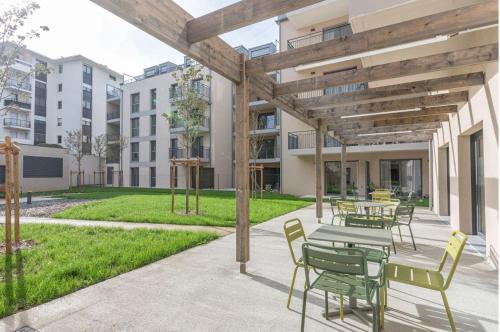 een terras met tafels en stoelen in een gebouw bij Résidence Angers in Angers