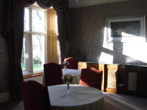 a dining room with a table and chairs and windows at St David's Guesthouse in Haverfordwest
