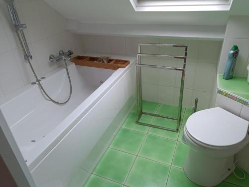 La salle de bains est pourvue d'une douche, de toilettes et d'une baignoire. dans l'établissement Maison de charme rénovée, à Guérande