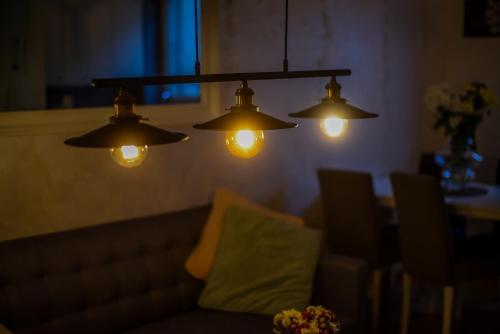 a living room with a couch and three lights at Panorama Central Apartments in Belgrade