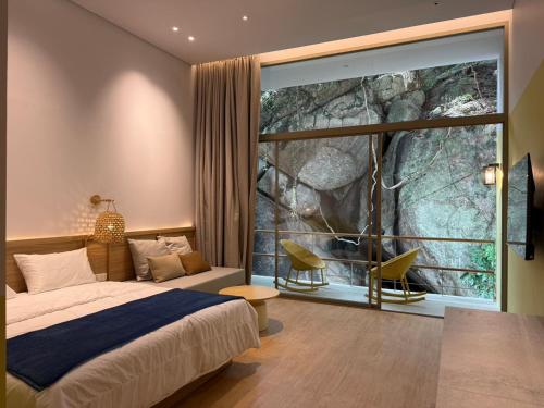 a bedroom with a bed and a large window at Ozone Cave in Thong Nai Pan Noi