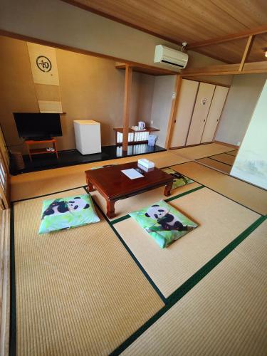 a living room with a table and two mats at 和みの宿いろり 甘露の湯付き in Shirahama