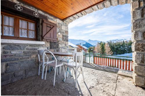 a patio with a table and chairs on a balcony at Chalet -Les Aiguilles- rdc in Albiez-Montrond