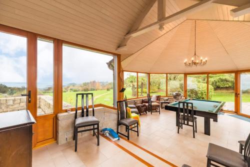 un salon avec une table de billard et des chaises dans l'établissement Grande maison parc paysager fantastique vue mer plage a 600m a pied, à Paimpol