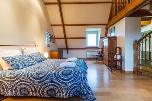 - une chambre avec un lit bleu et blanc et un escalier dans l'établissement Grande maison parc paysager fantastique vue mer plage a 600m a pied, à Paimpol
