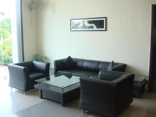 a living room with a couch and chairs and a table at Hotel Vikramaditya in Gangānagar