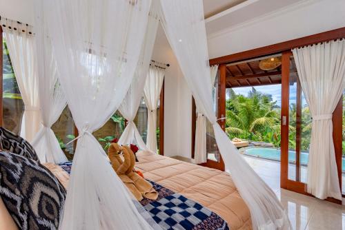 een slaapkamer met een bed met een teddybeer erop bij Villa Kanwa in Tampaksiring