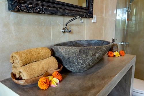 een badkamer met een grote stenen wastafel op een aanrecht bij Villa Kanwa in Tampaksiring