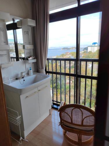 a kitchen with a sink and a large window at 和みの宿いろり 甘露の湯付き in Shirahama