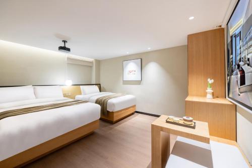 a hotel room with two beds and a tv at Beijing Tangfu Nanluoguxiang Wang Fu Jing Forbidden City Snack Street Hotel,1 stop walking to airport express,3 stop to tiananmen&Free Laundry Dry Service and Free Afternoon Tea &professional Free Tour Ticket Service with English Speaking Staff in Beijing