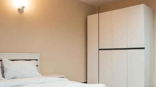 a bedroom with a bed and a white cabinet at Nattidaplace Hotel Chiangmai in Chiang Mai