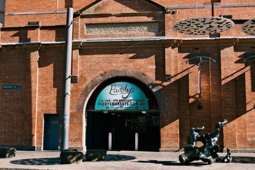 a brick building with a sign in front of it at Metro Aspire Hotel Sydney in Sydney