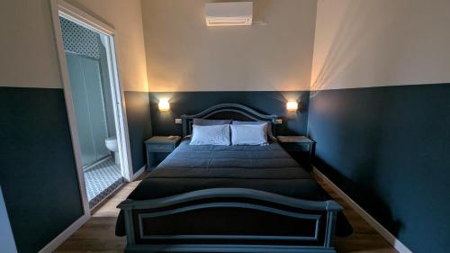 a bedroom with a bed with a blue wall at A Casa di Nonna in SantʼAngelo in Theodice