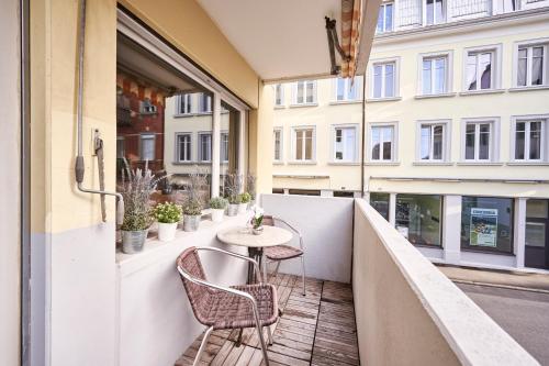 a balcony with a table and chairs on a building at Stay Switzerland Apartments in Interlaken