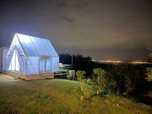 a blue house on top of a field at night at กระโจม Howland Glamping Khaoyai in Ban Nong Song Hong
