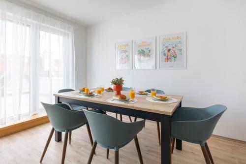 a dining room table with chairs and orange juice at Hock Residence by Vagabond in Budapest