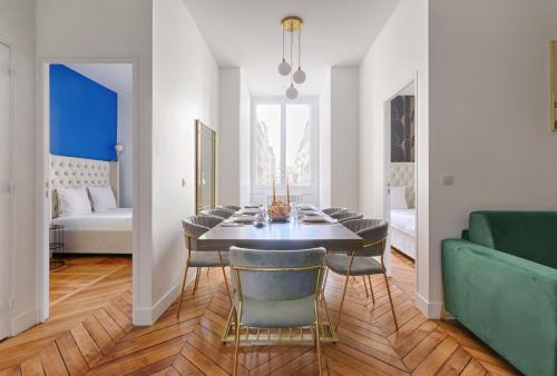 une salle à manger avec une table et un canapé vert dans l'établissement Convivialité pour 8 personnes - Parc Monceau, à Paris