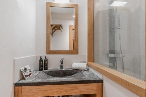une salle de bain avec un lavabo et un miroir dans l'établissement La Cremaillere, à Sallanches