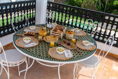 a table with breakfast food on a balcony at Maison Marine in Oualidia