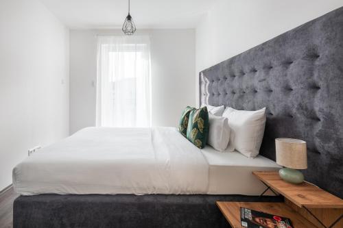 a bedroom with a large bed with a large headboard at Hock Residence by Vagabond in Budapest
