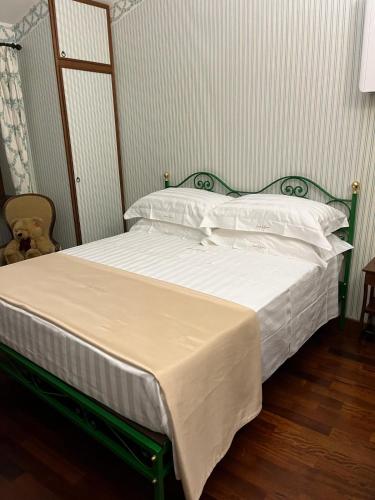 a bed with a green frame and white sheets and pillows at Casale La Quercia in Poggio Bustone