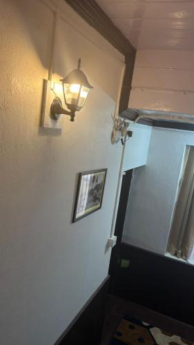 a hallway with a light on the wall and a stairway at Mellow Fellow Hostel Darjeeling in Darjeeling