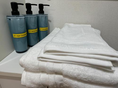 a pile of towels on a counter with two trash cans at Kenzo House in Kawasaki