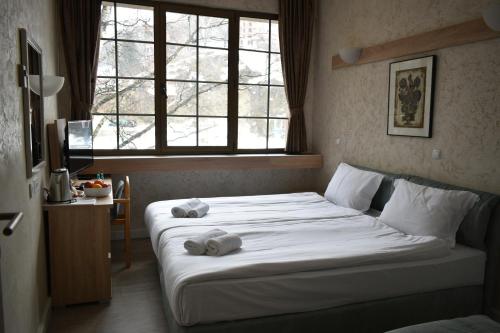 a bedroom with a bed with two towels on it at Hotel Fersped in Mavrovo