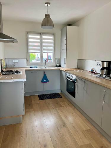 une cuisine avec des appareils blancs et un parquet dans l'établissement L'Hippocampe, terrasse, à 5 min' à pieds de la mer !, à Wimereux