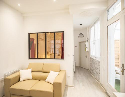 un salon avec un canapé et une fenêtre dans l'établissement Le Joli Patio - Parking Inclus - Hypercentre, à Troyes