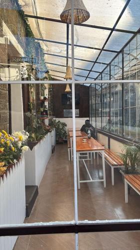 a restaurant with a table and benches and windows at Mellow Fellow Hostel Darjeeling in Darjeeling