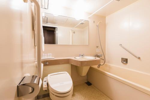 a bathroom with a toilet and a sink at Hotel Jogakura in Aomori