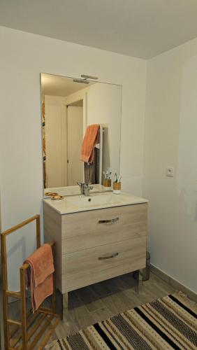 une salle de bain avec un lavabo et un miroir dans l'établissement Confort face montagne, à Embrun