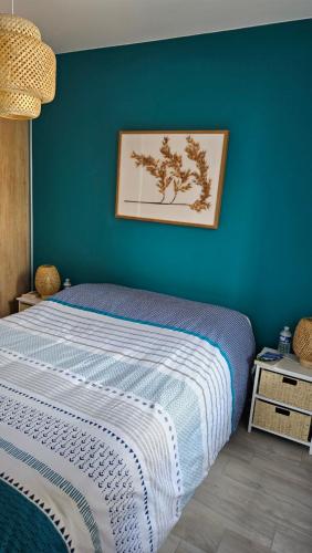 une chambre avec un lit avec un mur bleu dans l'établissement Confort face montagne, à Embrun