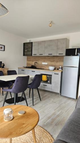 Il comprend une cuisine équipée d'un réfrigérateur, d'une table et de chaises. dans l'établissement Confort face montagne, à Embrun