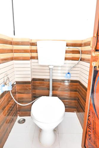 a bathroom with a white toilet in a room at vaidehi homlee premium stay, 3kms from Shri Ram janmbhoomi, Ayodhya in Faizābād
