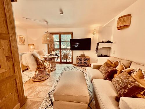 a living room with a couch and a tv at SEIN Boutique Suites - ADULTS ONLY in Gosau