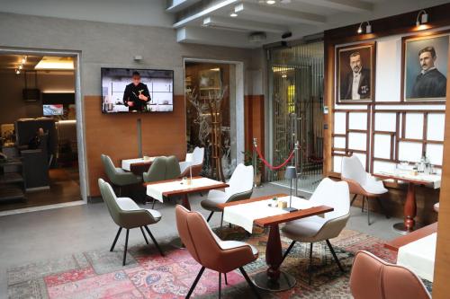 a restaurant with tables and chairs and a flat screen tv at Zepter Hotel Belgrade, member of Zepter Hotels in Belgrade