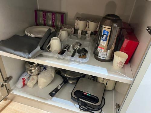 a cupboard with utensils and other kitchen items at Wadi Front Apartment 2 in Nizwa