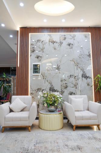 a lobby with two chairs and a table with flowers at South Gate Hotel Apartment in Addis Ababa