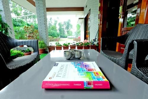 a book sitting on top of a table at Doddanandi Homestay - 3BH Full Villa, AC, Home Food, Coffee Estate in Chikmagalur