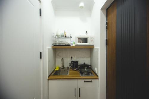 a small kitchen with a sink and a microwave at Twins Tower 5 in Tbilisi City
