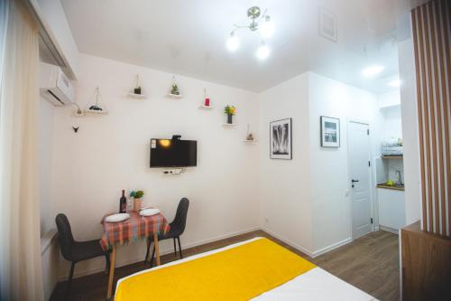 a living room with a table and a yellow rug at Twins Tower 5 in Tbilisi City