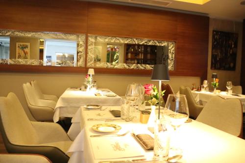 a restaurant with tables and chairs with white tablecloths at Zepter Hotel Belgrade, member of Zepter Hotels in Belgrade