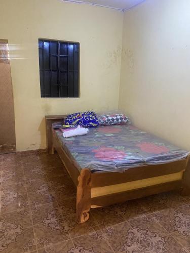 a small bed in a room with a window at Brikama line house in Brikama
