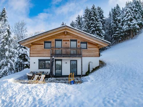a log cabin in the snow with a balcony at Chalet Alpenherz in Kirchberg in Tirol