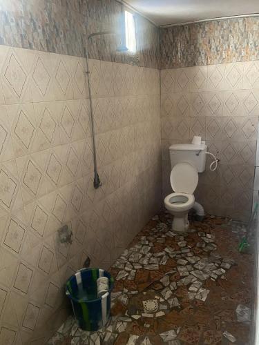 a dirty bathroom with a toilet in a room at Brikama line house in Brikama