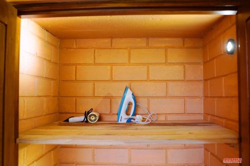 a shelf in a brick walled room with items on it at Cinnamon Hills Cabana in Alutwala